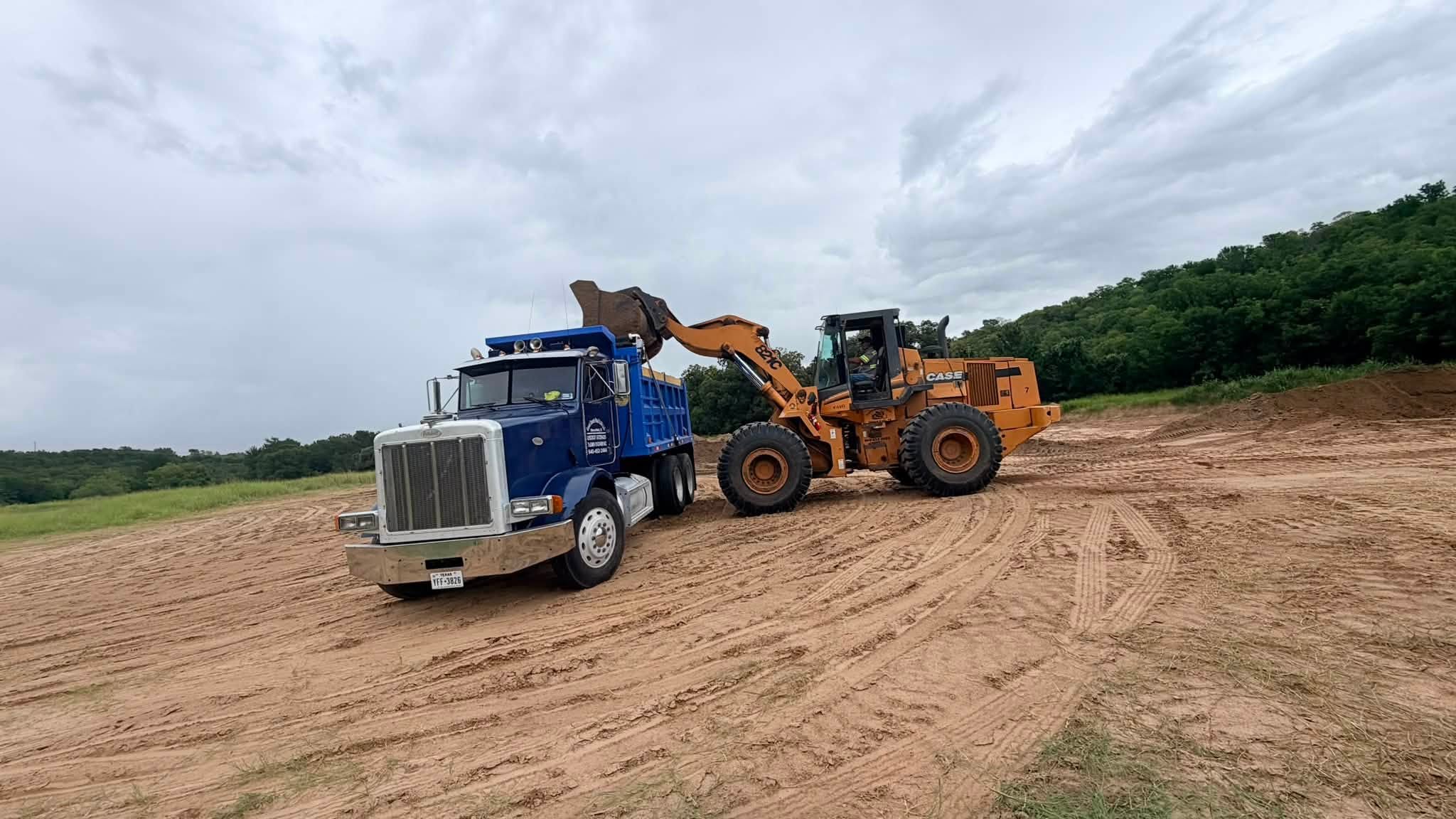 Dump truck and loader moving dirt on a job site