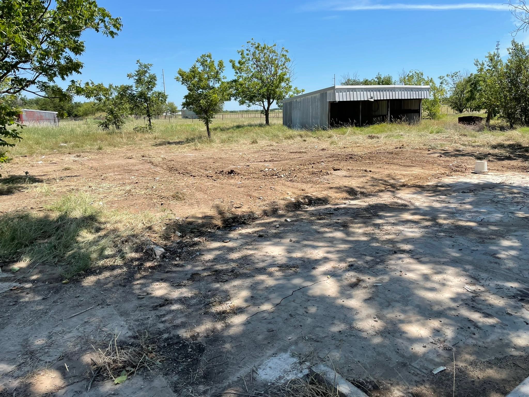 Same property after cleanout: debris removed and ground cleared